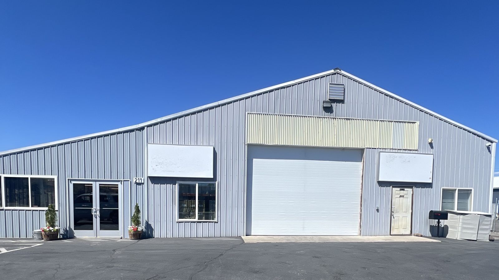 The Vet-Ex building: a gray metal-sided building with a large white roll-up door, at 211 E Naches Ave in Selah